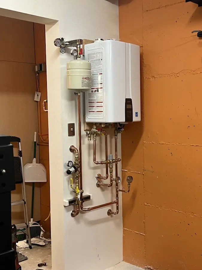 Plumbing technician inspecting water heater connections in Williamstown